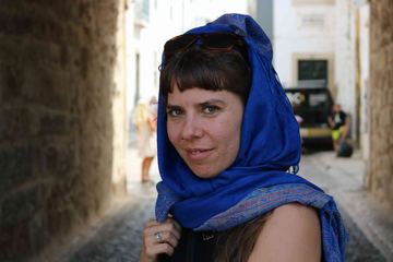 Adina mit blauem Tuch in einer Altstadtgasse